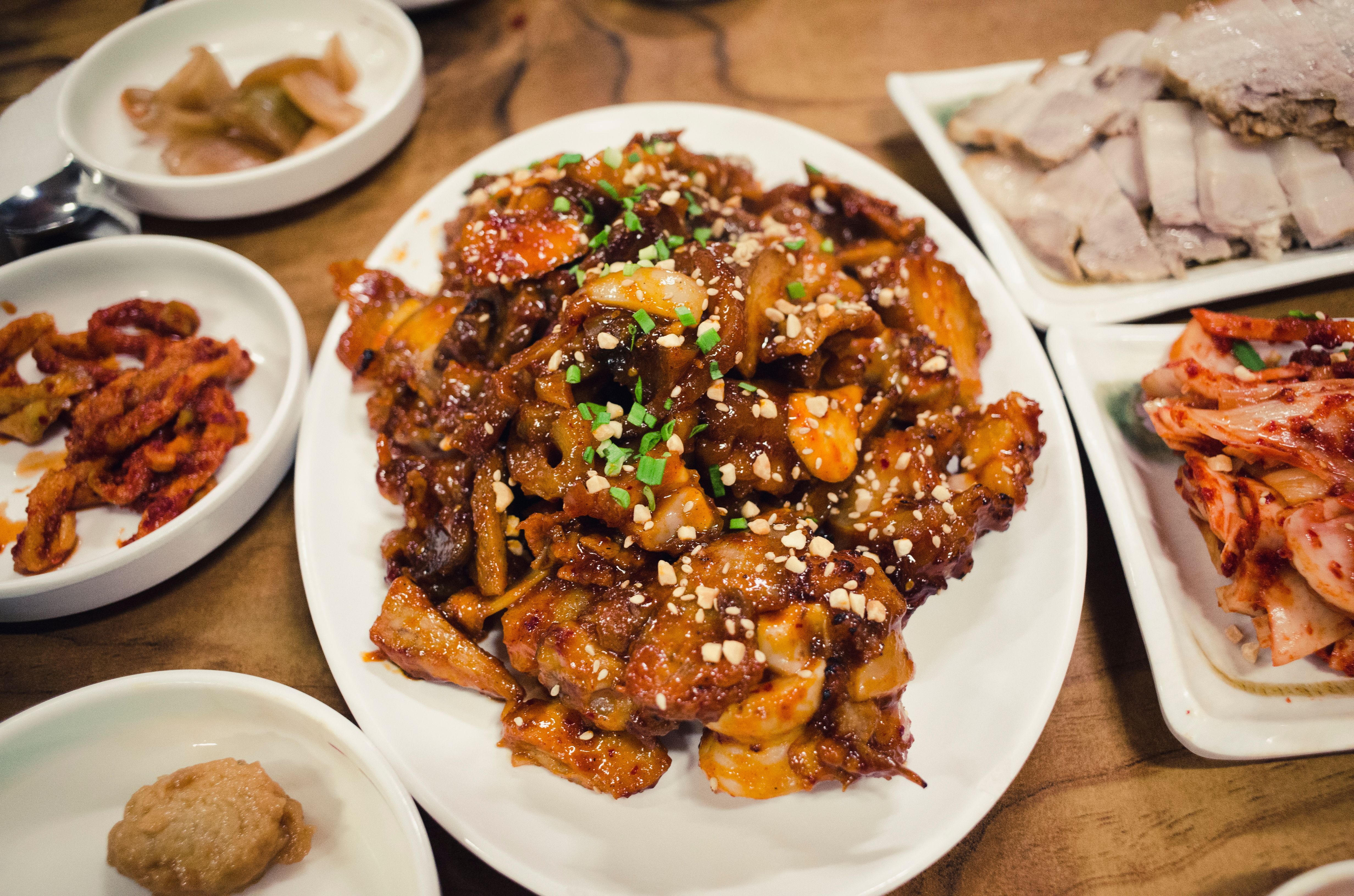 An appetizing spread of Korean dishes featuring spicy pork, kimchi, and side dishes.