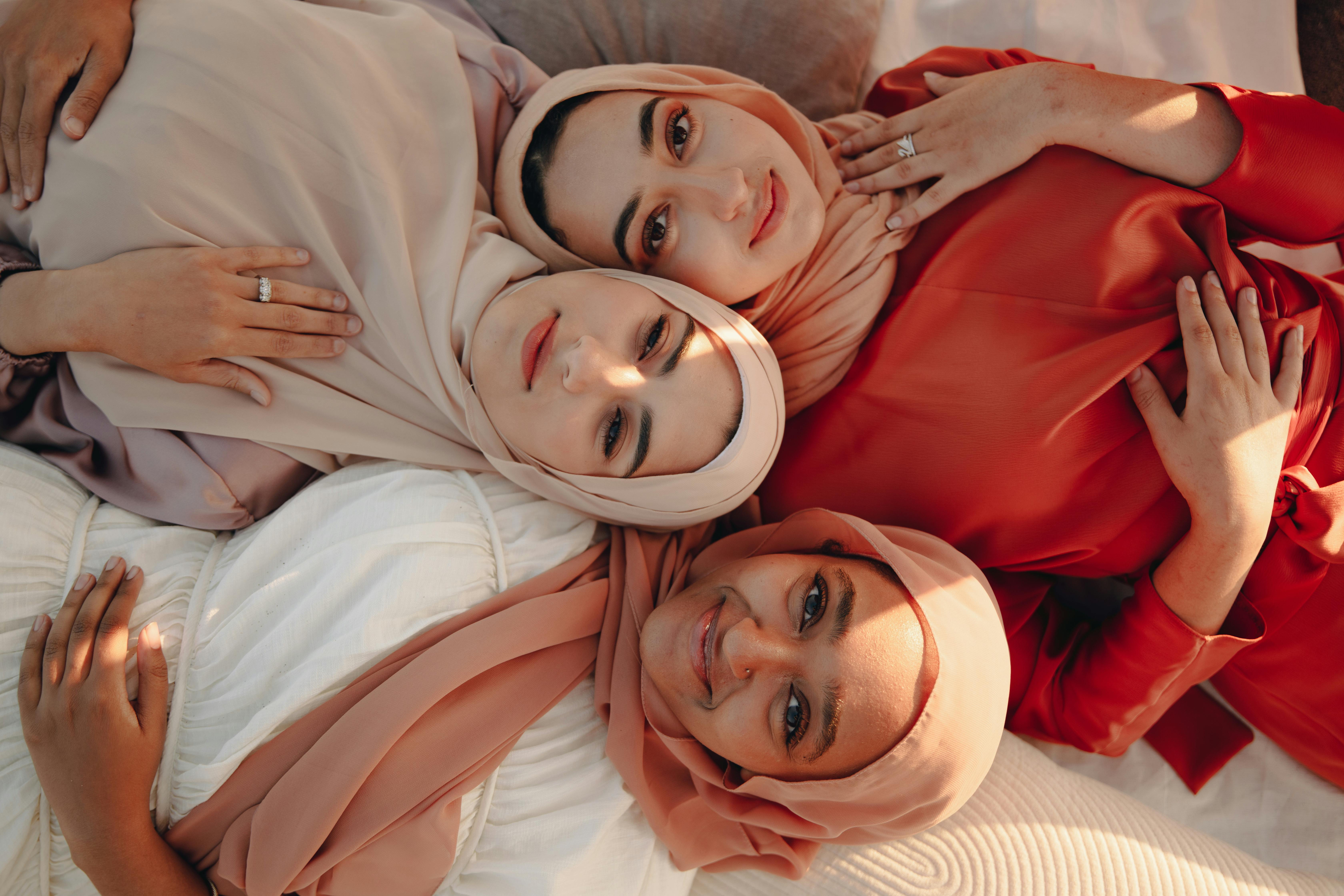 women wearing hijabs lying close together