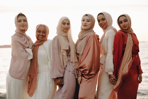 Group Photograph of Muslim Women Wearing Pink Headscarves, Posing on a Seaside