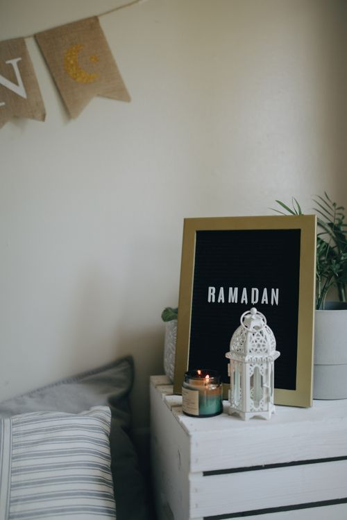 Free Chic Ramadan side table decor with lantern, candles, and festive board. Stock Photo