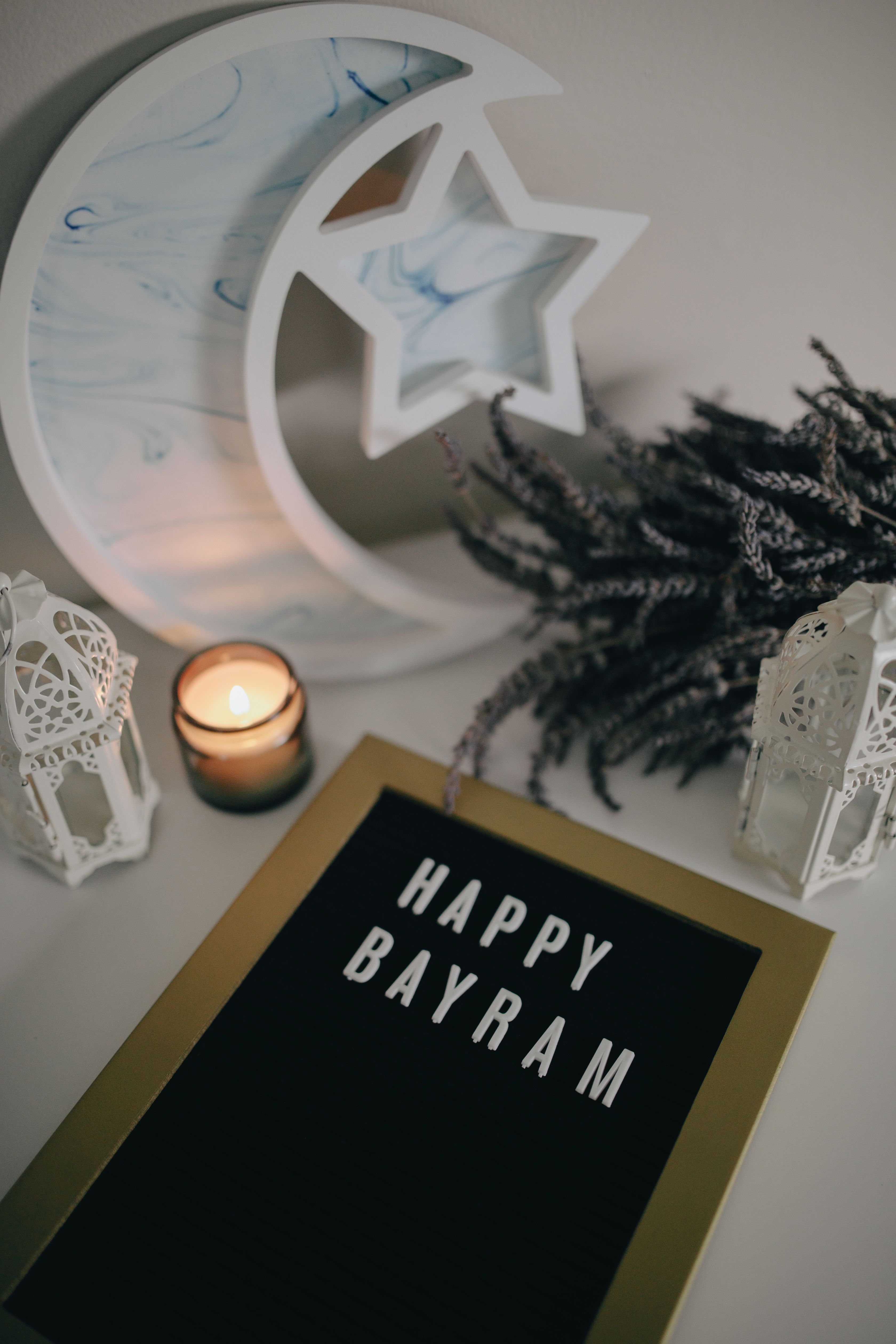 Stylish Bayram celebration setup with candle, lavender, and decorative lanterns.