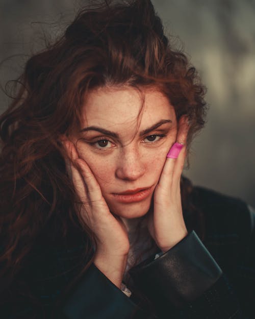 Close-Up Shot of a Woman Holding Her Cheeks