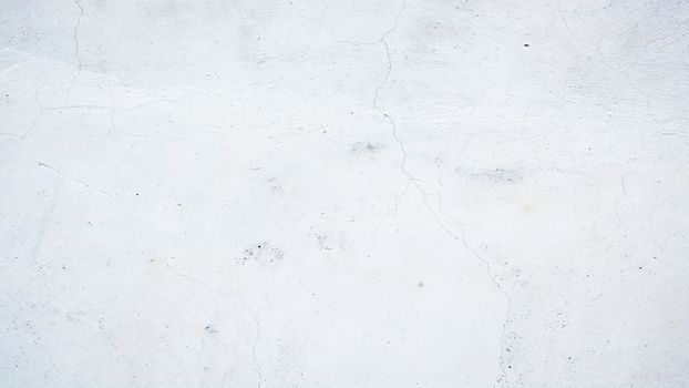 Close-up of a white concrete wall with subtle cracks and texture.