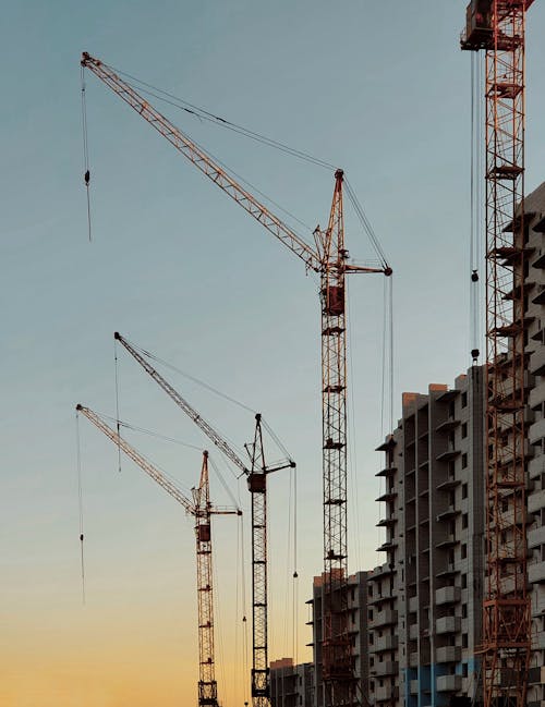 Blocks of Flats and Cranes Machinery against the Sky