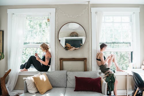 Women Sitting on Window Sills