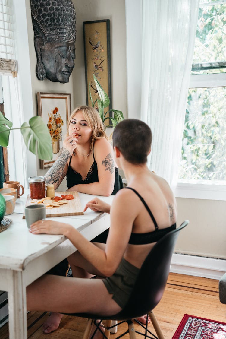 A Couple Sitting At Table Eating Breakfast