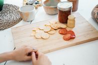 Person Holding Brown Wooden Chopping Board With Brown Cookies