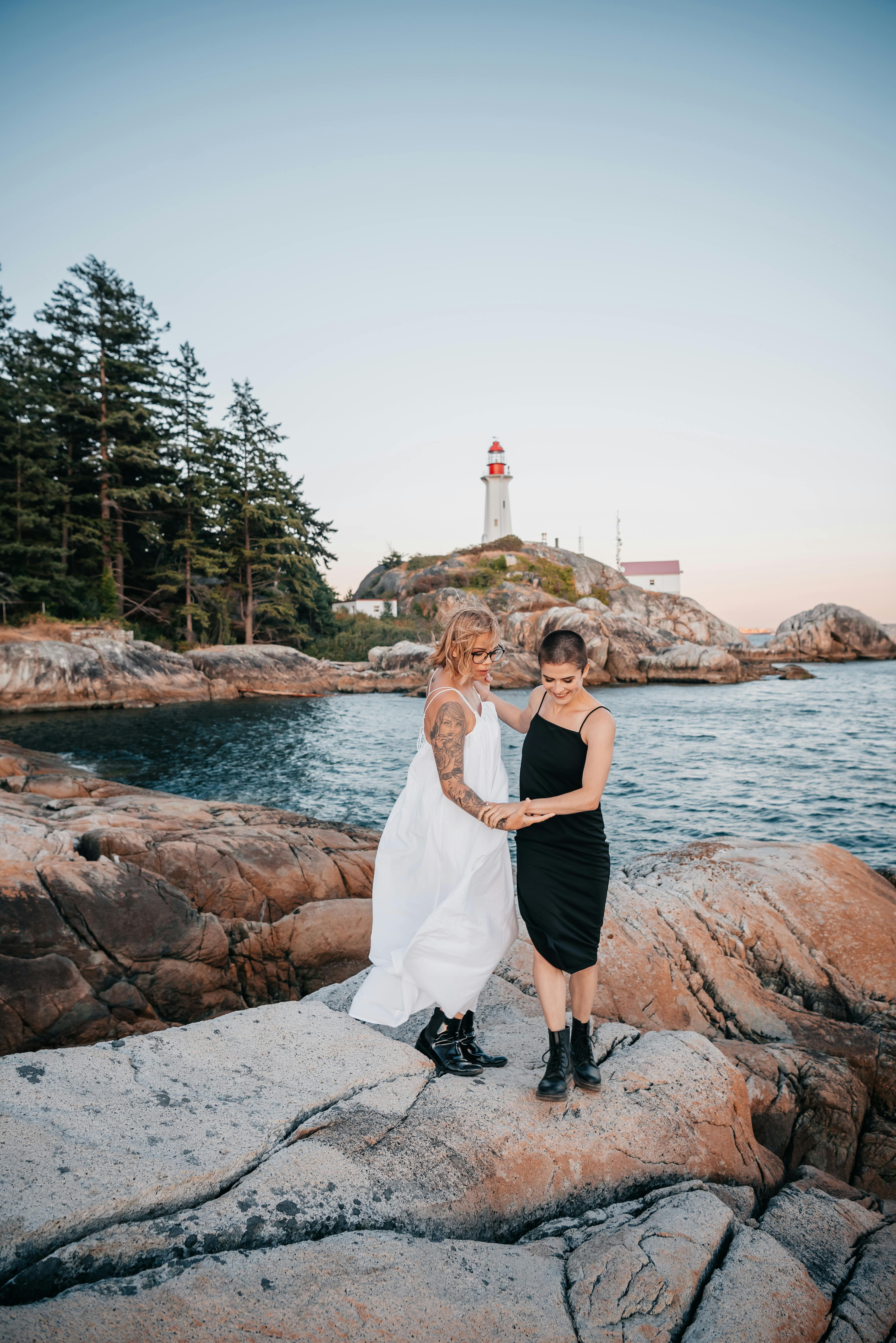 a couple in dresses standing on rock