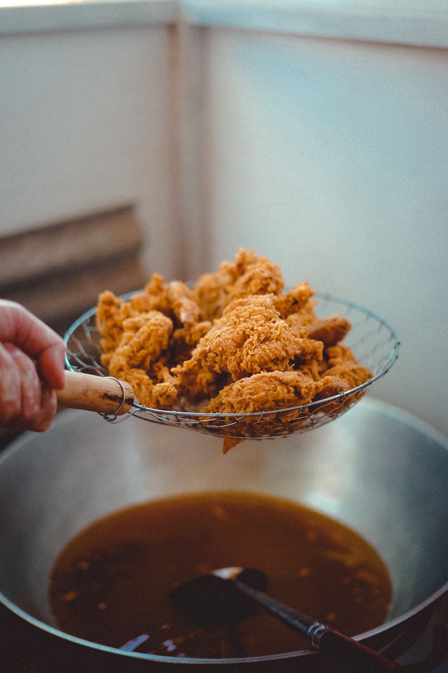Hand battered chicken frying in the Ember Bird kitchen