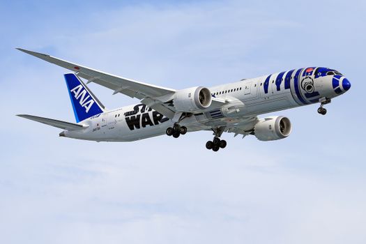 A Boeing 787 Dreamliner with Star Wars themed livery flying against a blue sky.