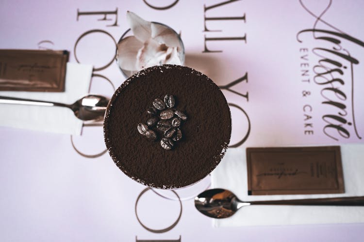 Top View Of A Coffee Dessert And Spoons On Lilac Background 