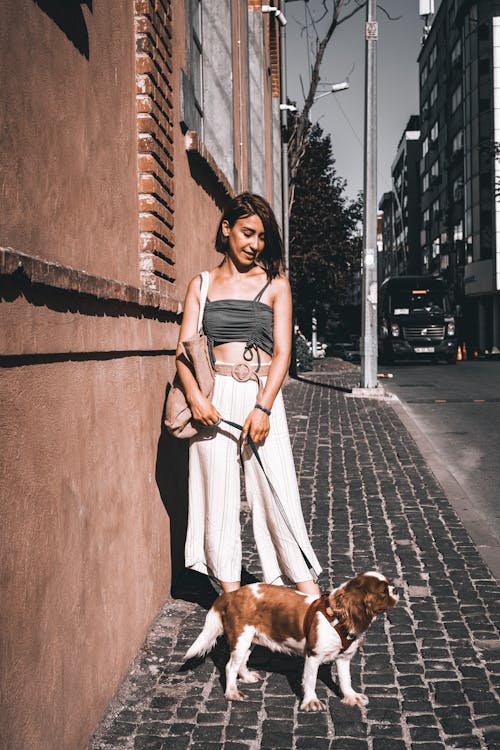 A Woman on the Sidewalk With Her Pet 