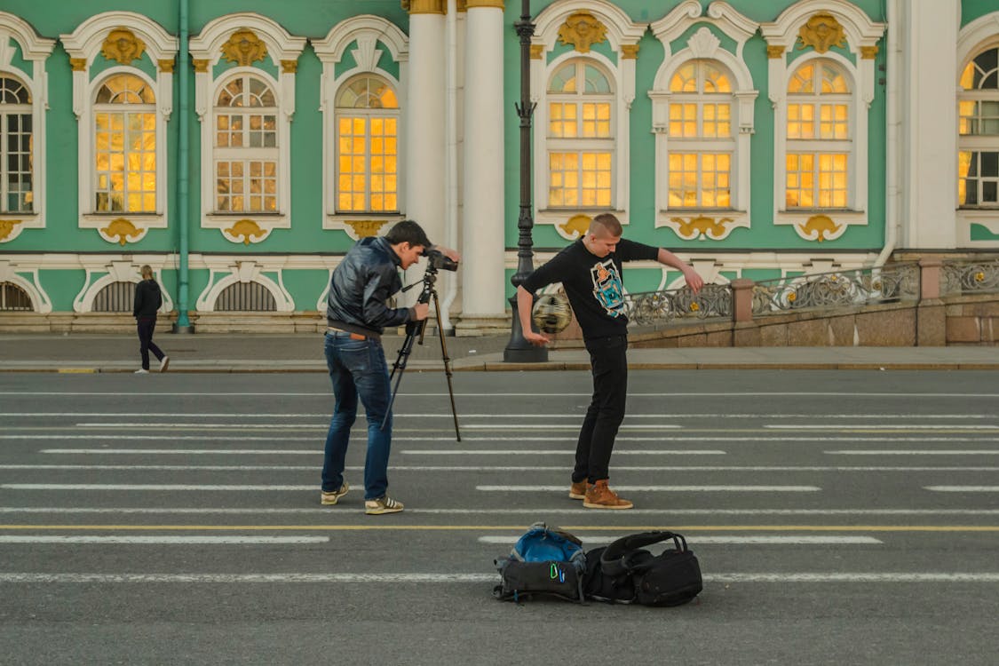 Free Man in Black Jacket Taking a Photo of Man in Black Crew Neck T Shirt Stock Photo