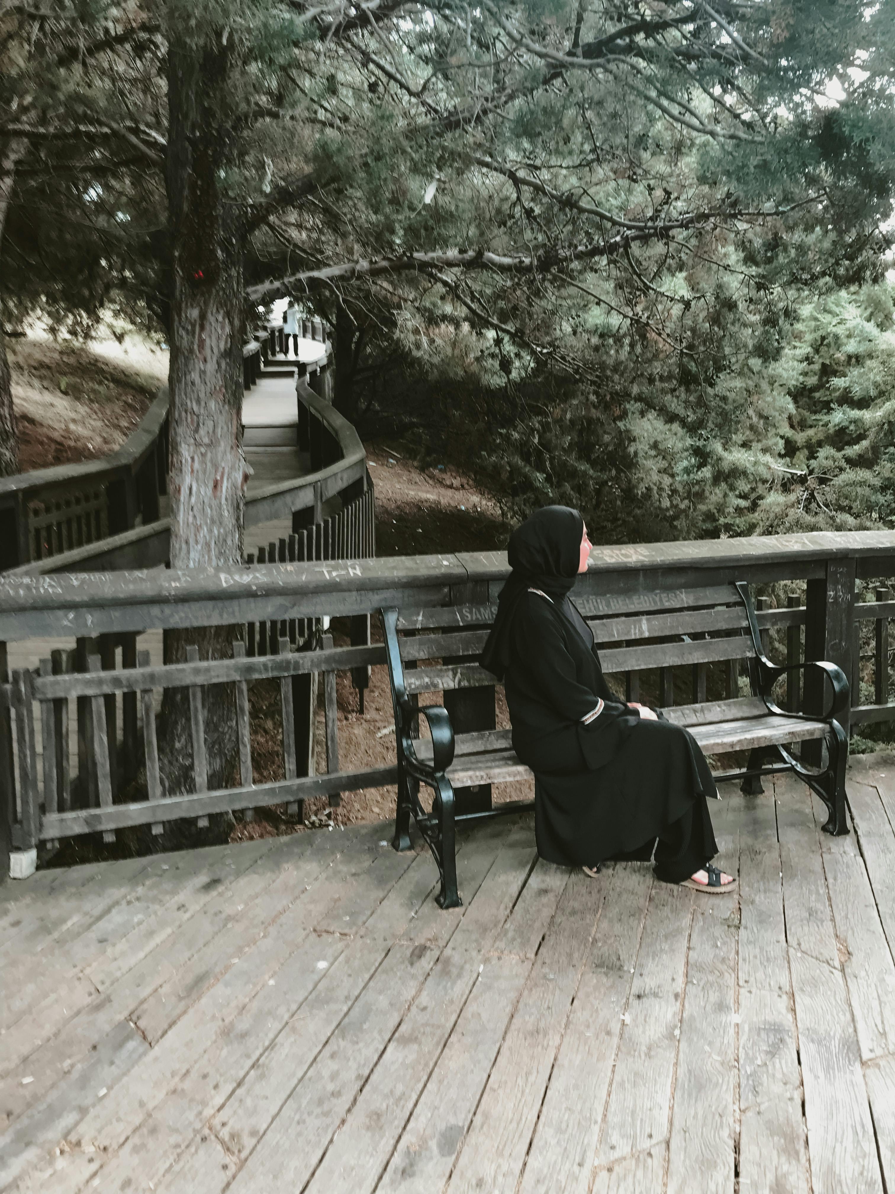 Woman in gray hijab and black leggings sitting on brown wooden bench photo  – Free Iran Image on Unsplash