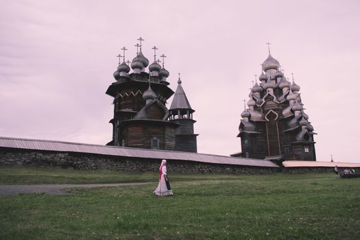 Woman Walking on a Field in Front of Kizhi Pogost, the Church of Transfiguration 