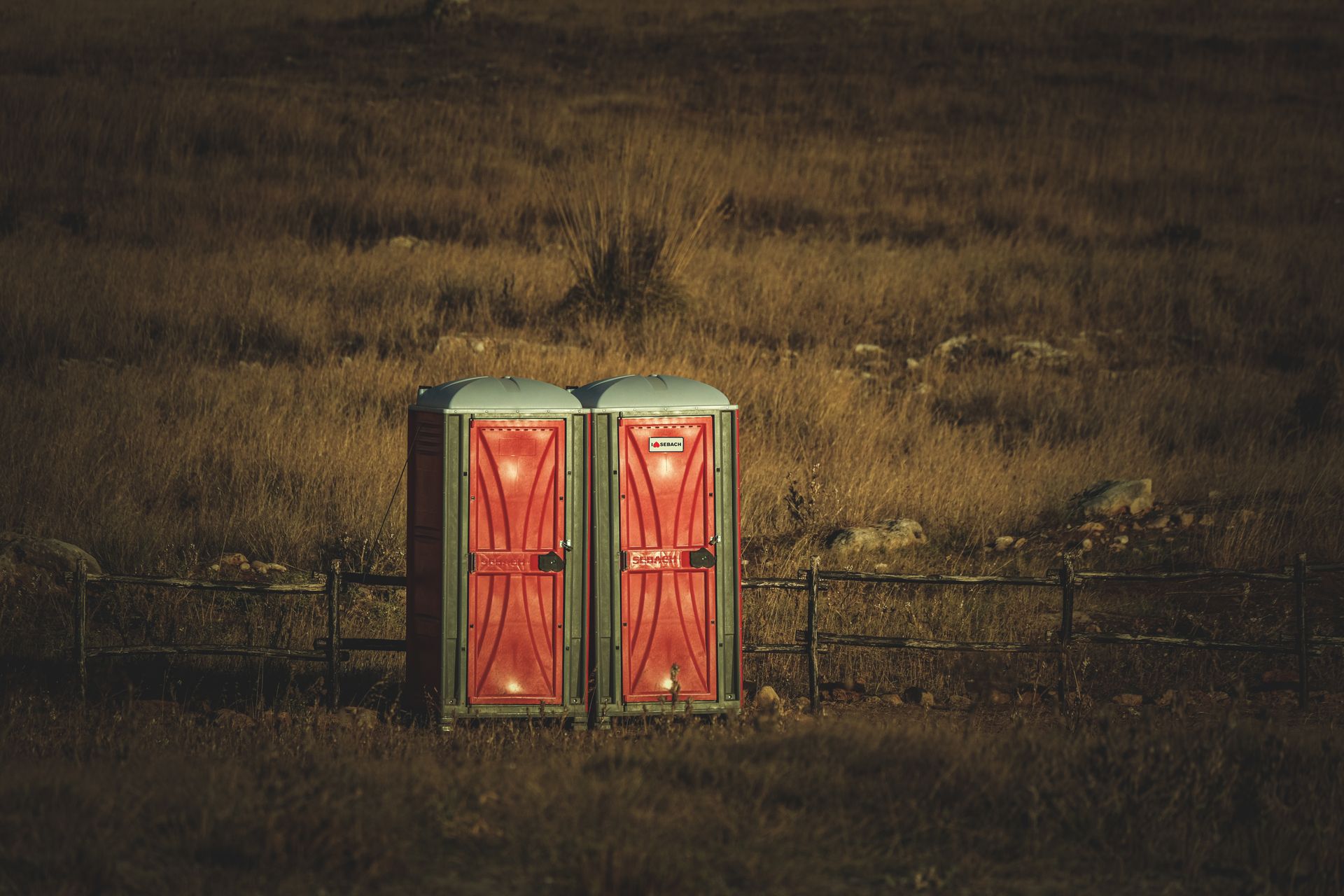 Two Portable Toilets on a Field