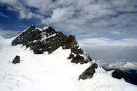 在明亮的蓝天下，白雪皑皑的山峰景色壮丽