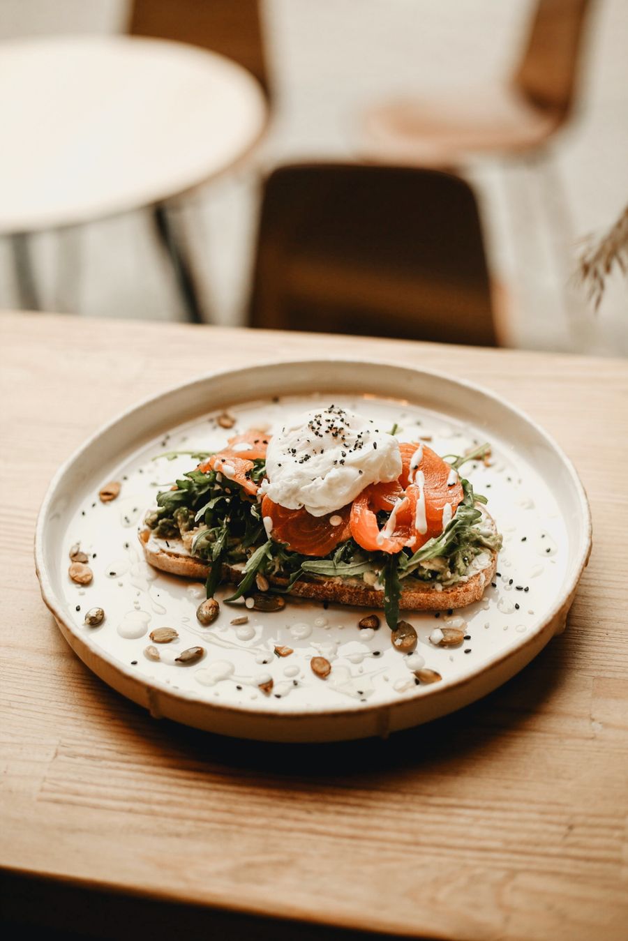 Smoked salmon and avocado toast with a poached egg on a wooden table