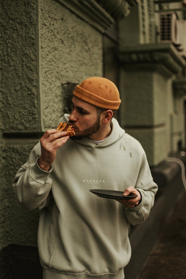 Man Eating A Pie On The Street