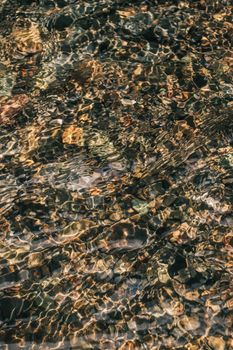 Artistic shot capturing the patterns and reflections on a rippled water surface, creating an abstract effect.