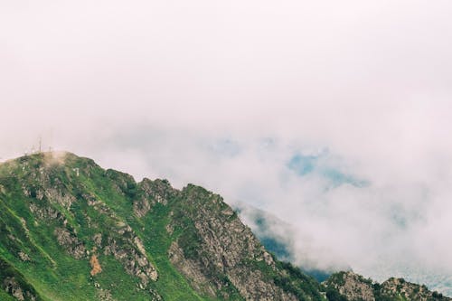 A Big Green Mountain Under White Thick Clouds