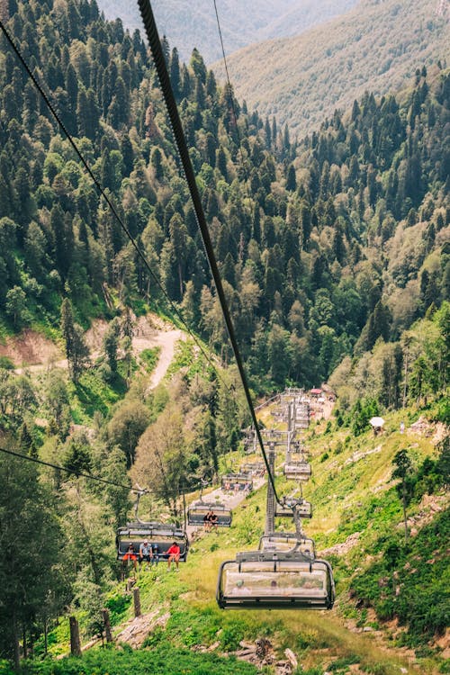 Chair Lift Cable Car Over Green Trees and Mountains
