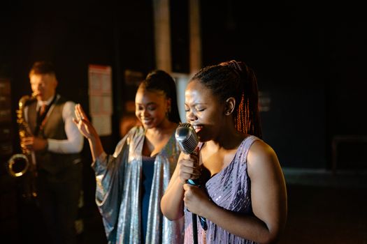 Vocalist sings passionately with saxophonist in a lively jazz performance.