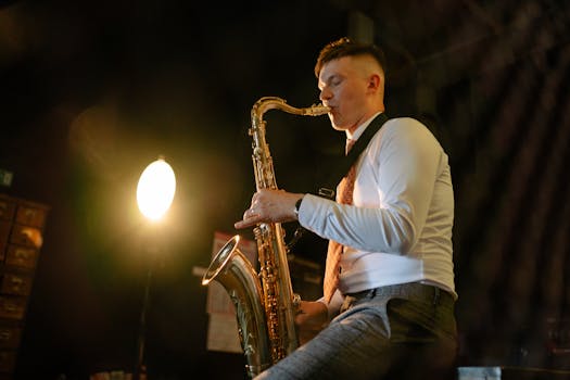 A male saxophonist playing under a spotlight, creating a moody musical atmosphere.
