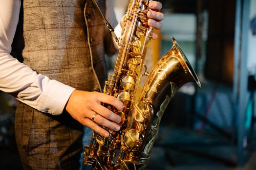 Free Detailed image of hands playing a golden saxophone, showcasing the intricate design and craftsmanship of the instrument. Stock Photo