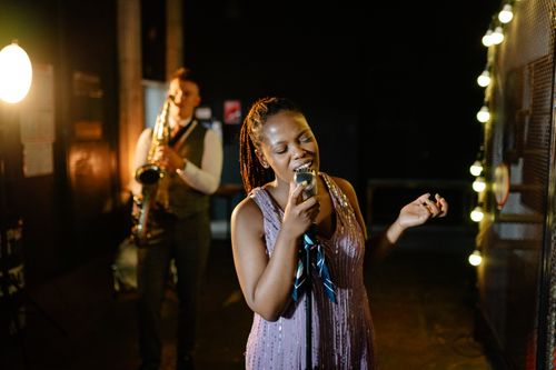 Free A captivating moment of a singer performing with a saxophonist in a dimly lit jazz venue. Stock Photo