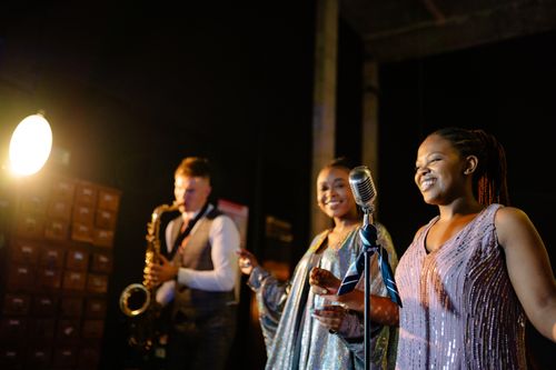 Free Diverse jazz band performing with singers and saxophonist on stage. Stock Photo