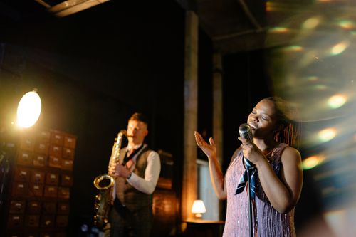 Free Intimate jazz performance featuring a saxophonist and a singer on stage, creating a mesmerizing ambiance. Stock Photo