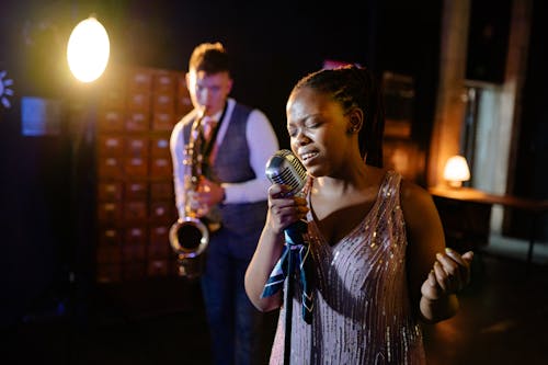 A Woman Singing While a Man Plays the Saxophone