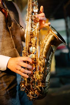 Close-up of a musician playing a shiny saxophone with intricate details indoors.