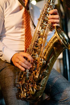Detailed image of hands playing a saxophone, highlighting musical elements.