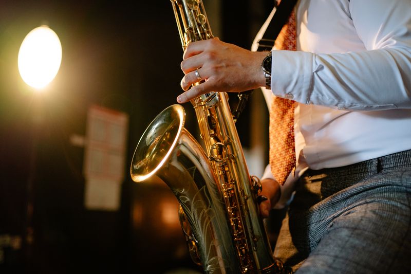 Saxophonist playing under warm stage light