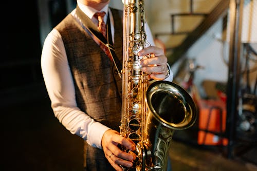 A Man in Brown Suit Vest Playing the Saxophone