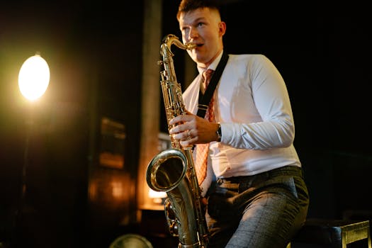 A saxophonist engages in an elegant performance, illuminated by warm stage lighting.