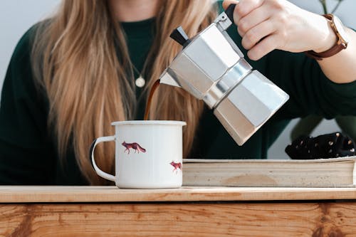 A Person Pouring Coffee in a Mug 