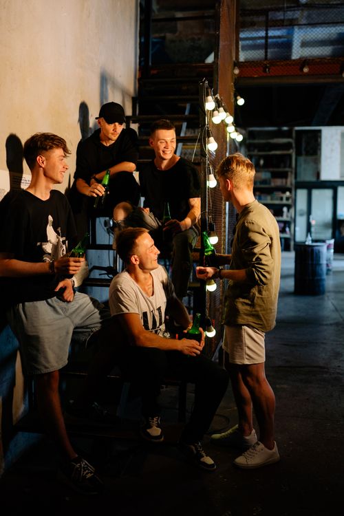 Free Group of young men enjoying drinks and conversation at a trendy urban gathering. Stock Photo