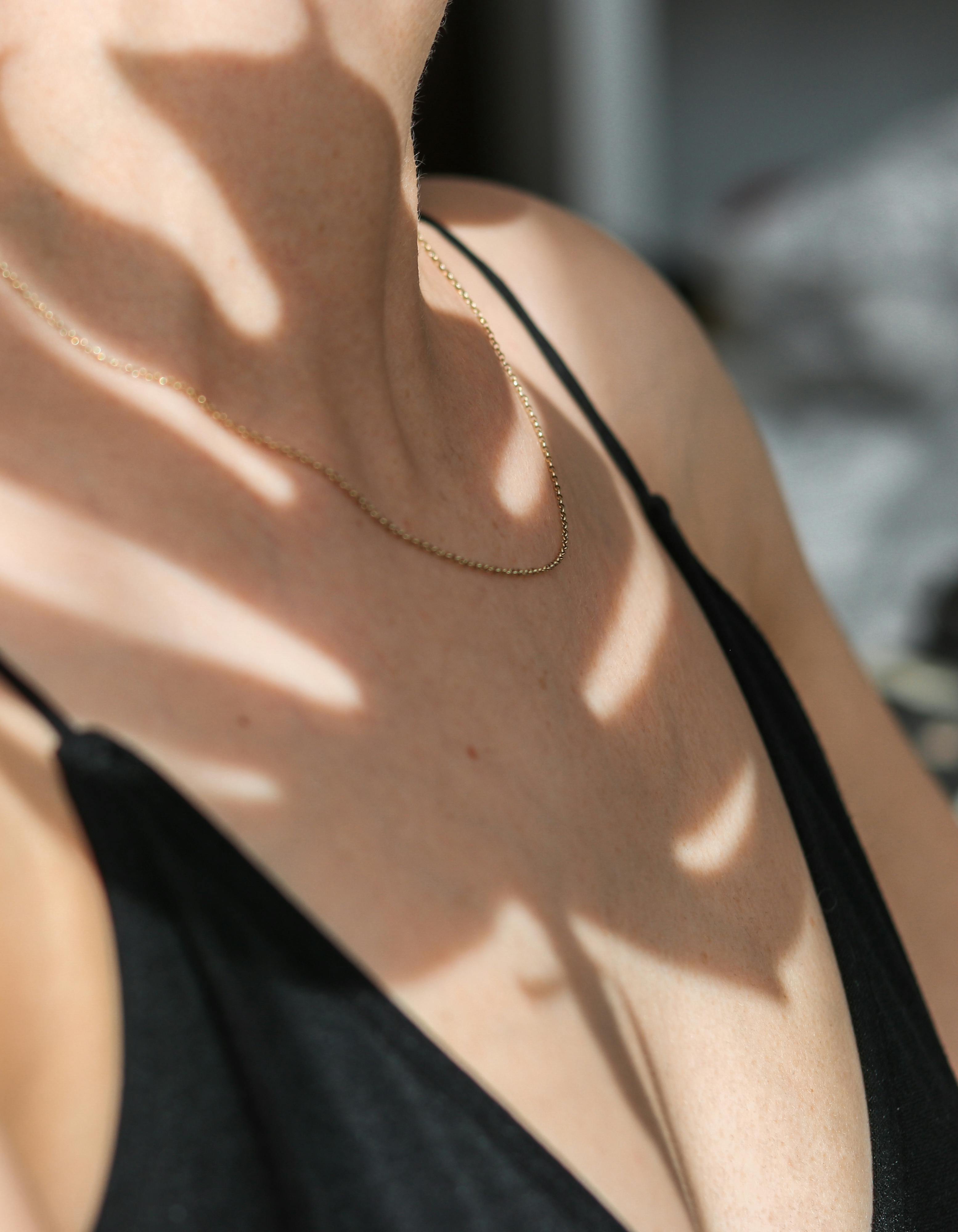 woman in black top with gold necklace