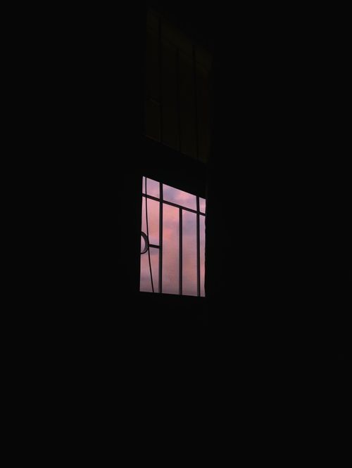 Free Dark room with window view of colorful sunset sky in Mumbai. Stock Photo