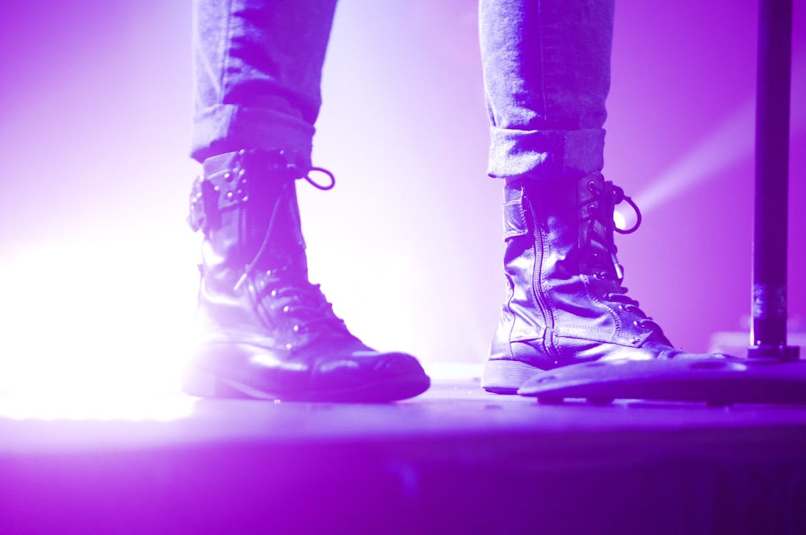 Человек в ботинках на шнуровке, стоящий на сцене