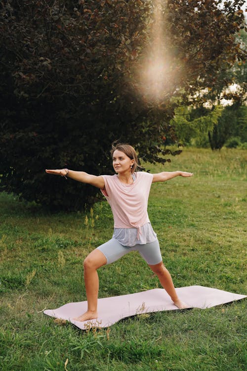 Woman Standing on a Yoga Mat Spreading Her Arms Wide