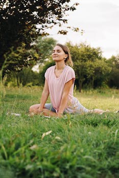 Adult woman meditating in a peaceful outdoor park setting, embracing healthy living and mindfulness.