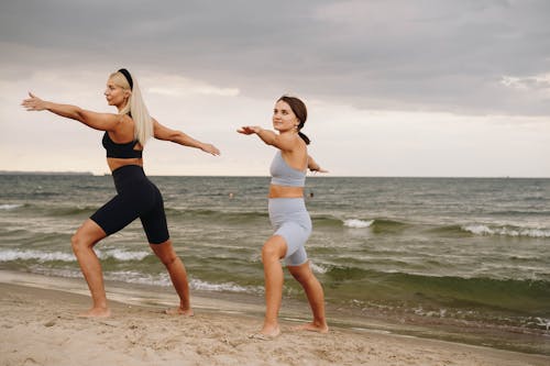 People Doing Yoga at the Beach