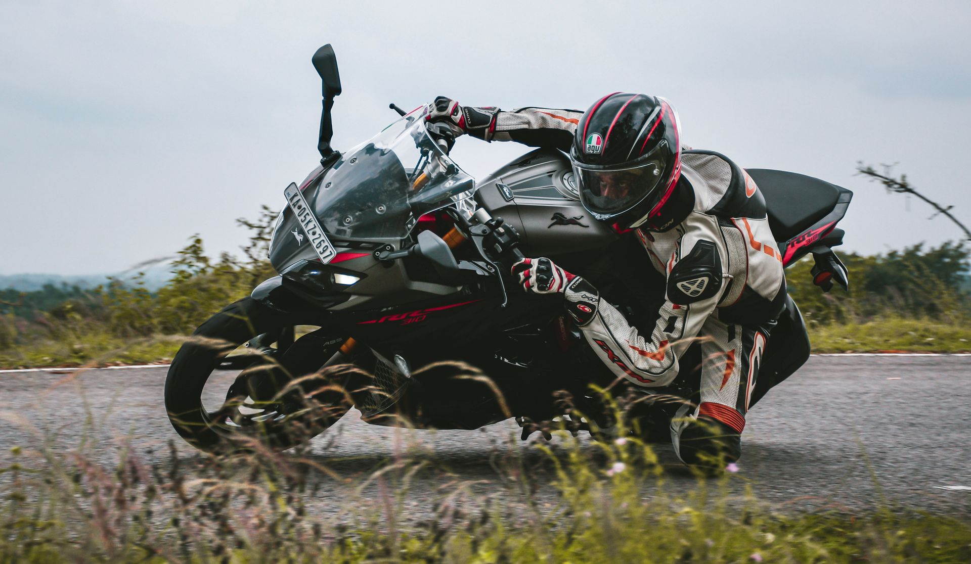 Exciting motorcycle racing scene with rider leaning into a curve on a winding road.