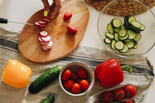 Free Vibrant vegetables like peppers and cucumbers on a rustic kitchen table, perfect for healthy recipes. Stock Photo
