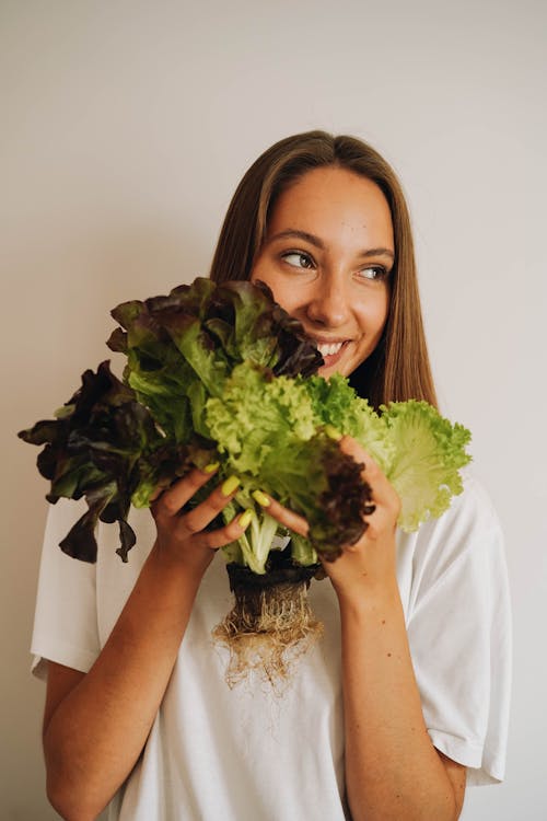 A Woman Smiling While Holding a Lettuce