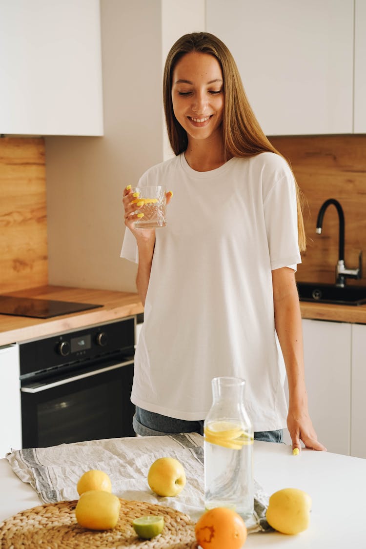 A Woman Holding A Water With Lemon